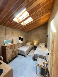 a bedroom with two beds and a table and chairs at Casa da Esquila Ilha do Pico 2 in Cais do Pico