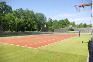 einen Tennisplatz mit einem Netz und einem Basketballkorb in der Unterkunft Kase Holiday Center in Paiküla