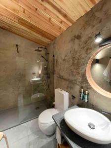 a bathroom with a sink and a toilet and a mirror at Casa da Esquila Ilha do Pico 2 in Cais do Pico