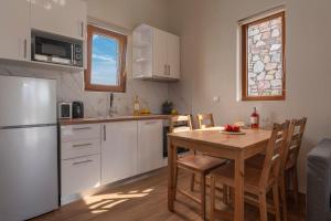 een keuken met een houten tafel en een witte koelkast bij Esperanza Villas in Flogita