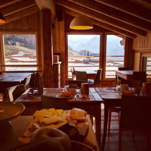 Lavarets Chambres d’Hôtes في أياس: غرفة طعام مع طاولات وإطلالة على الجبل