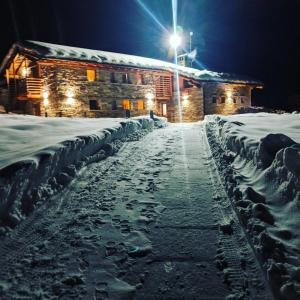 a snow covered street at night with a street light at Lavarets Chambres d’Hôtes in Ayas
