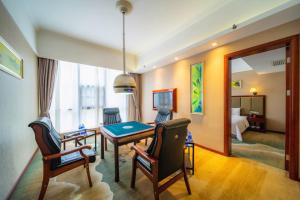 een kamer met een tafel en stoelen en een slaapkamer bij Changsha Jiaxing Inn in Changsha