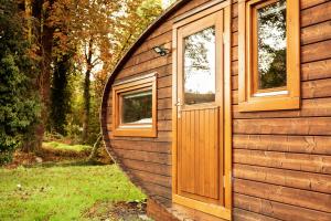 eine Holzhütte mit einer Tür und einem Fenster in der Unterkunft La caravana in Conty