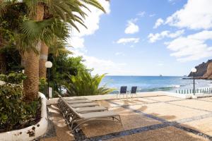 a group of chairs sitting next to the ocean at Vistamar beach in San Andrés