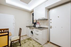 a kitchen with a washer and dryer next to a door at Flat w Balcony 5 min to Beach in Kemer in Antalya