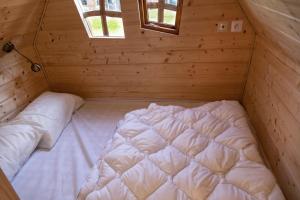 uma grande cama branca num quarto de madeira em La cabane magique em Conty