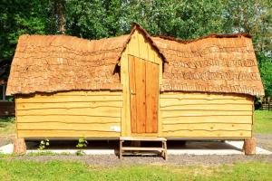 um barracão de madeira com telhado de palha em La cabane magique em Conty