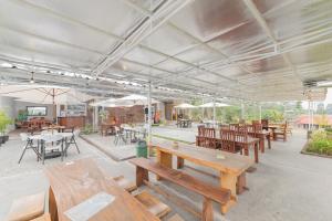 a cafeteria with wooden tables and chairs and umbrellas at Pondok Hefi Ciwidey RedPartner in Ciwidey