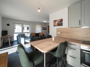 uma cozinha e sala de estar com uma mesa de madeira e cadeiras em Jade Glück Wilhelmshaven em Wilhelmshaven