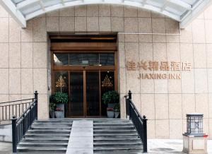 Changsha Jiaxing Inn في تشانغشا: مبنى فيه درج يؤدي لباب زجاجي