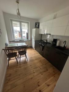 a kitchen with a table and chairs and a table and a dining room at Apartament Szymek in Toruń