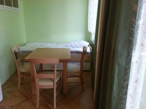 クラクフにあるApartament Familiaのテーブル、椅子、ベッドが備わる小さな客室です。