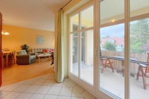a living room with a sliding glass door to a balcony at Jägerstrasse 7 Ferienwohnung 8 in Kölpinsee