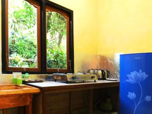 a kitchen with a sink and two windows at Dajan Buyan Homestay in Bedugul