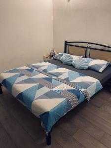 a bed with a blue and white quilt on it at Gabine - Self Check-in in Kaštela