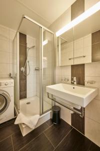 a bathroom with a sink and a shower and a washing machine at Perfect Location, comfortable & modern in Bern