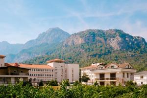 a group of buildings in front of a mountain at Nature View Flat w Terrace 5 min to Beach in Kemer in Antalya