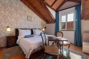 1 dormitorio con 1 cama, mesa y sillas en Heritage Hotel Pasike en Trogir