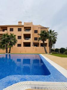 a hotel with a swimming pool in front of a building at Casa Michella - Golf and Seaview & Pet-Friendly in Los Alcázares