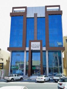 a building with cars parked in front of it at الماسةالتاج للشقق الفندقية in Hail