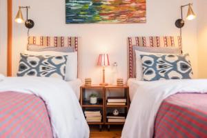 ein Schlafzimmer mit 2 Betten und einem Tisch mit einer Lampe in der Unterkunft Menagerie House Luxury City Cottage, Walk Score 98 in York