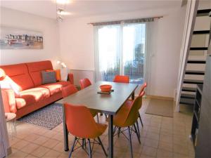 a living room with a table and chairs and a couch at Maisonnette JIKEL à 50 m de la plage in Sarzeau