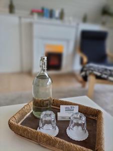 una botella y dos vasos en una bandeja en una mesa en Haus Tourneur, en Lippetal