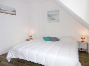 a white bed in a white room with two lamps at Maisonnette JIKEL à 50 m de la plage in Sarzeau