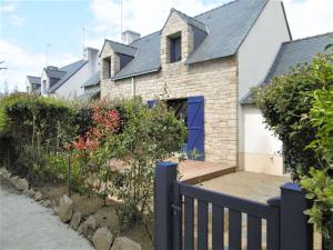 a house with a blue door and a fence at Maisonnette JIKEL à 50 m de la plage in Sarzeau