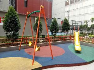 a playground with two swings and a slide at OYO LIFE ROOMS BY MIXO in Jakarta