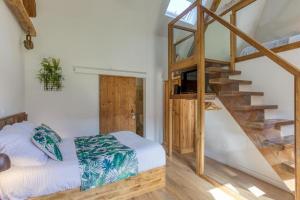 TreffortにあるGîte de charme : La grange au lac Azurのベッドルーム1室(ベッド1台付)、木製の階段 +28枚の写真