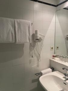Baño blanco con lavabo y espejo en Hotel Bitterfelder Hof - Mongoo GmbH, en Bitterfeld