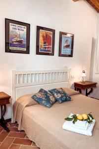 um quarto com uma cama com duas mesas e cartazes na parede em Astra - Villa Cenami - grande PISCINA con vista em Massarosa