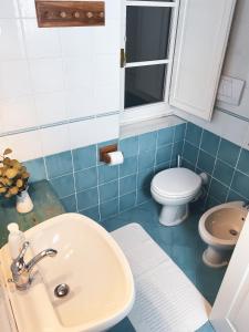 uma casa de banho com um lavatório e um WC em Astra - Villa Cenami - grande PISCINA con vista em Massarosa