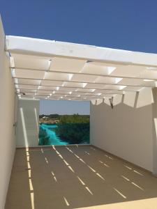 a white pergola on a building with a view at Vespucci Apartments Torre Lapillo in Torre Lapillo