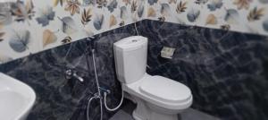 uma casa de banho com um WC branco e um lavatório. em Vegetable Garden House em Nallathanniya