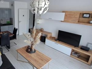 uma sala de estar com uma televisão e uma mesa em Apartament-Sweet Night em Lubin