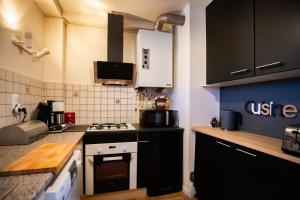 a kitchen with black cabinets and a stove top oven at La Forêt Mountain views Parking in Font-Romeu-Odeillo-Via