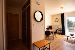 a living room with a mirror and a table at La Forêt Mountain views Parking in Font-Romeu-Odeillo-Via