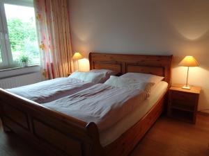 1 cama en un dormitorio con 2 lámparas y una ventana en Ferienwohnung Martens, en Fockbek