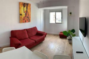 uma sala de estar com um sofá vermelho e uma televisão em Cozy 3bd near vibrant Valencia em Paiporta