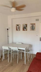 einen Esstisch mit Stühlen und einen Deckenventilator in der Unterkunft Cozy 3bd near vibrant Valencia in Paiporta