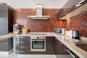 プラヤ・ブランカにあるVilla El Anclaのレンガの壁、ステンレス製の電化製品が備わるキッチン