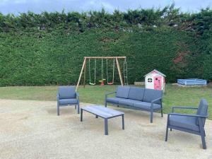 einen Spielplatz mit zwei blauen Stühlen und einer Schaukel in der Unterkunft Gite un bren de bonheur in Bren