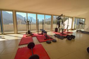 un gimnasio con máquinas de ejercicio en una sala con ventanas en Waterfall Residence, en Antalya