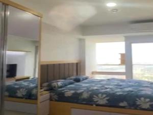 ein Schlafzimmer mit einem Bett und einem großen Spiegel in der Unterkunft OYO Life 93164 Pacific Alam Sutra in Tangerang