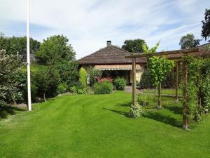 un jardín con cenador y césped verde en Ferienwohnung Martens, en Fockbek