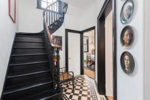 約克的住宿－Menagerie House Luxury City Cottage, Walk Score 98，走廊上设有黑色楼梯和 ⁇ 格地板