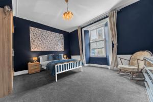 - une chambre bleue avec un lit et une chaise dans l'établissement Georgian Manor House, à Whitehaven